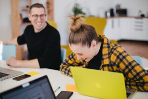 Zwei lachende Personen im Büro