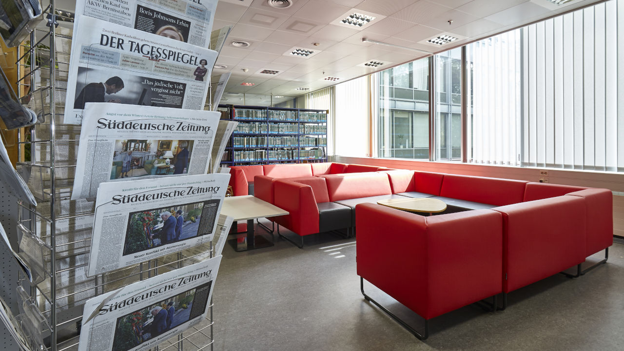 Foto der Zeitungsleseecke mit Sofa und Zeitungsständer